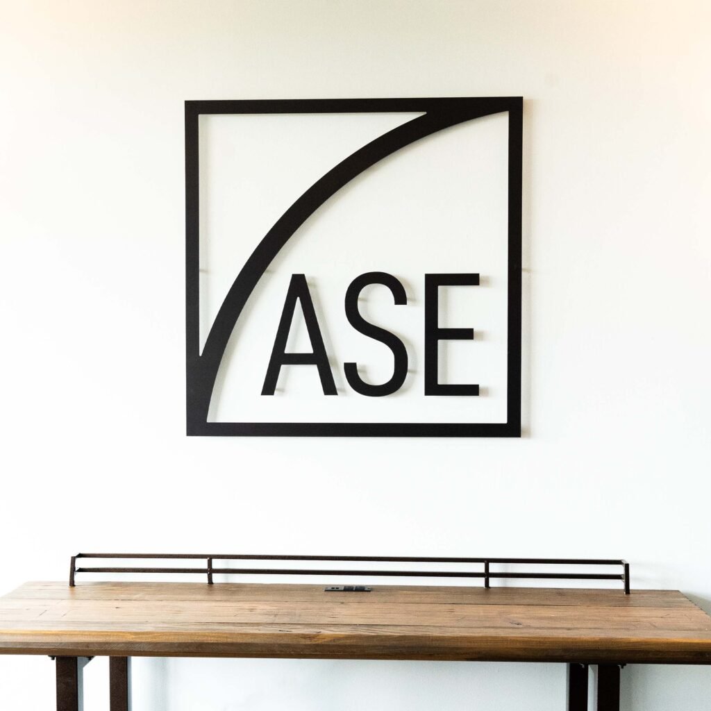 Black minimalist indoor sign above wooden table.