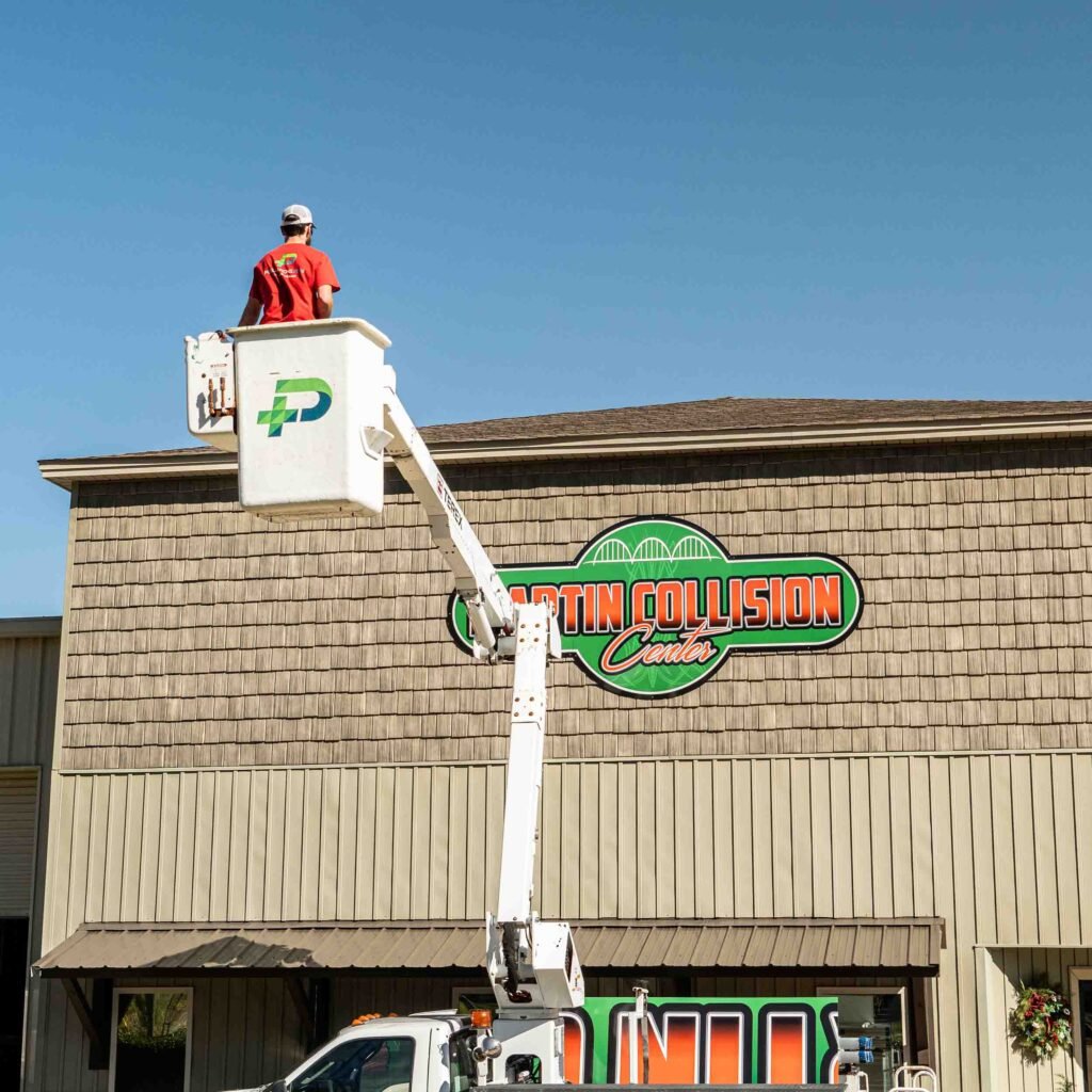 Man in bucket truck installing an outdoor sign.