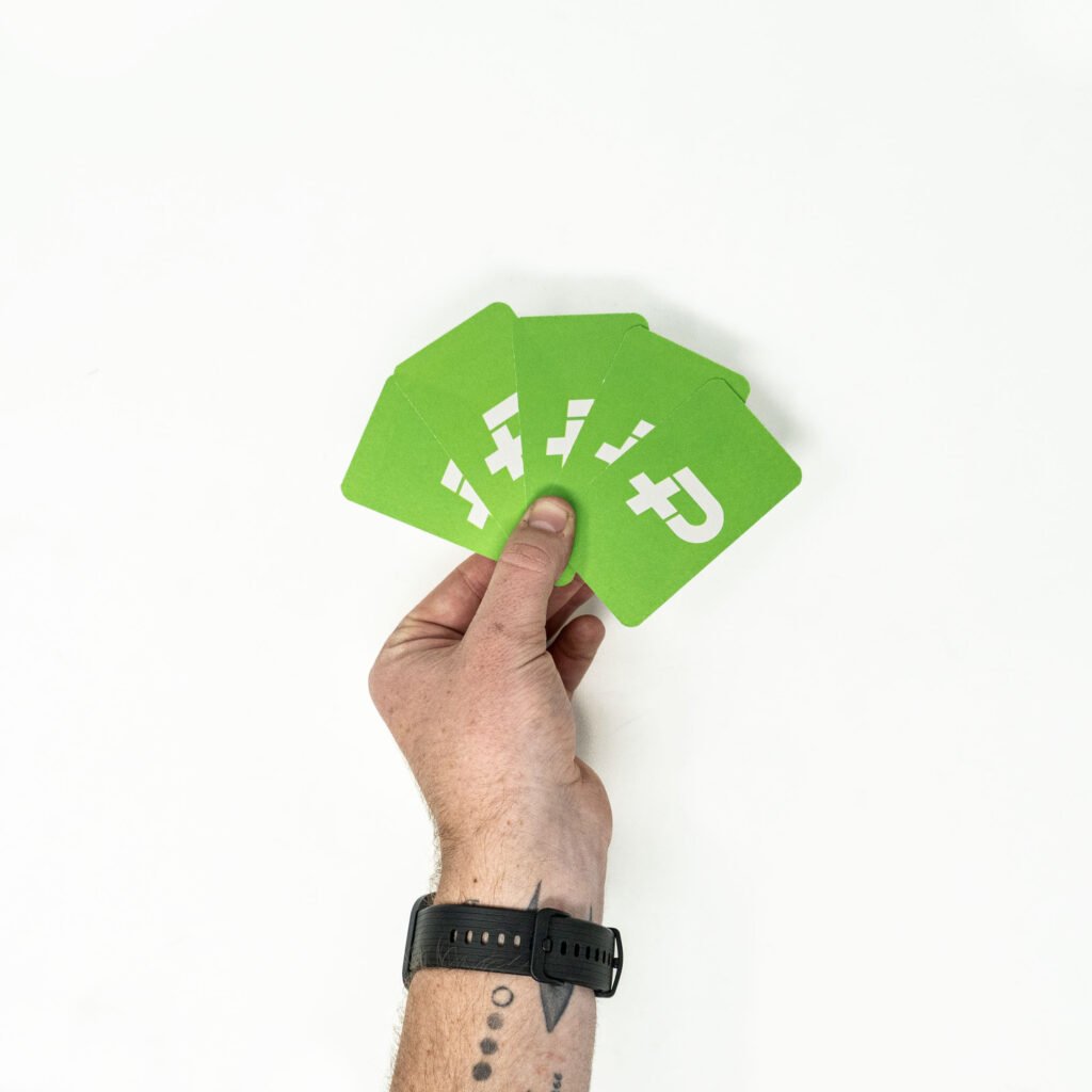 Hand holding green business cards with rounded corners.