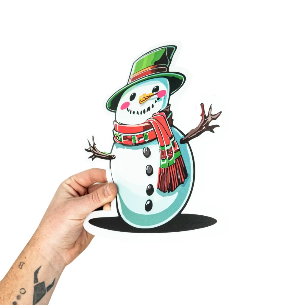 Hand holding Christmas themed window cling sample print.